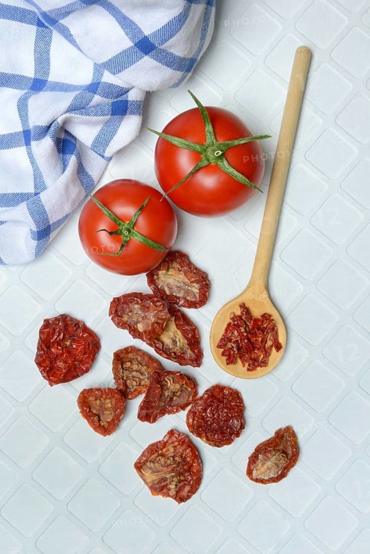Fresh and dried tomatoes with wooden spoon, Solanum lycopersicum