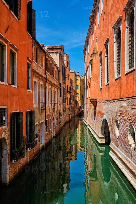 Narrow canal between colorful old houses in Venice, Italy