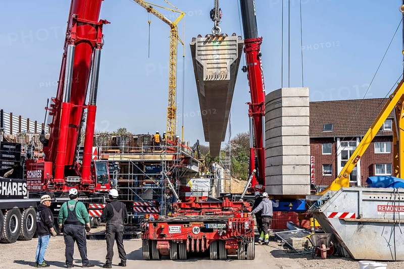 First part of the assembly of the new, 120-meter-long A516 motorway bridge, across Teutoburger Straße in Oberhausen-Sterkrade, 2 large cranes lift the 24 bridge sections weighing up to 121 tons and up to 40 meters long, which are then connected by tendons using a globally unique process, the prefabrication of the bridge parts and the construction process reduces the construction time from 24 to 7 months, per direction, the bridge, built in 1970 was severely damaged, traffic continues to roll on the still existing West Bridge, after which the Completion of this bridge, the western part is also demolished and then rebuilt, traffic rolls in one lane on the new bridge, North Rhine-Westphalia, Germany
