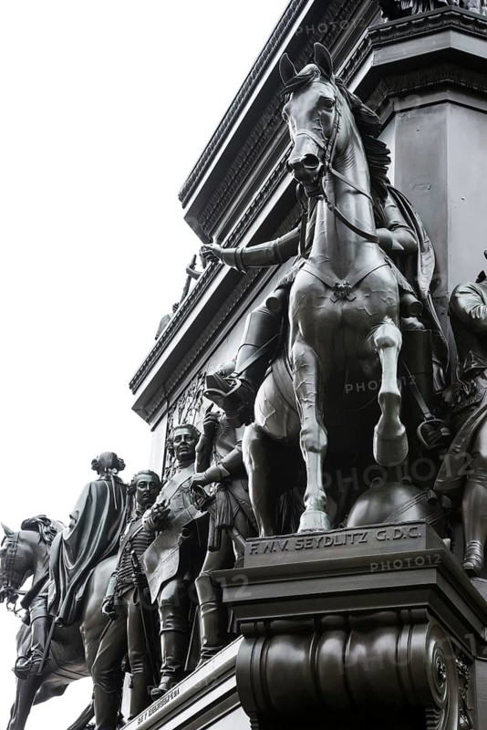 Historical equestrian statue of Frederick the Great at the Forum Fridericianum from 1839-1851, cavalry general Friedrich Wilhelm Freiherr von Seydlitz-Kurzbach in uniform on a horse with fearful eyes and open mouth, artist: Christian Daniel Rauch, Berlin School of Sculpture, transition from classicism to realism, bronze, bronze sculpture, pedestal, portrait, imposing, equestrian monument, equestrian statue, sculpture, detailed historical depiction, Berlin Mitte, City of Berlin, Germany
