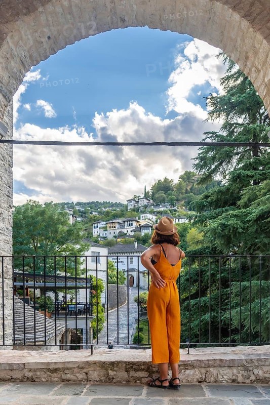 A tourist woman looking at the city of Gjirokaster or Gjirokastra. Albanian