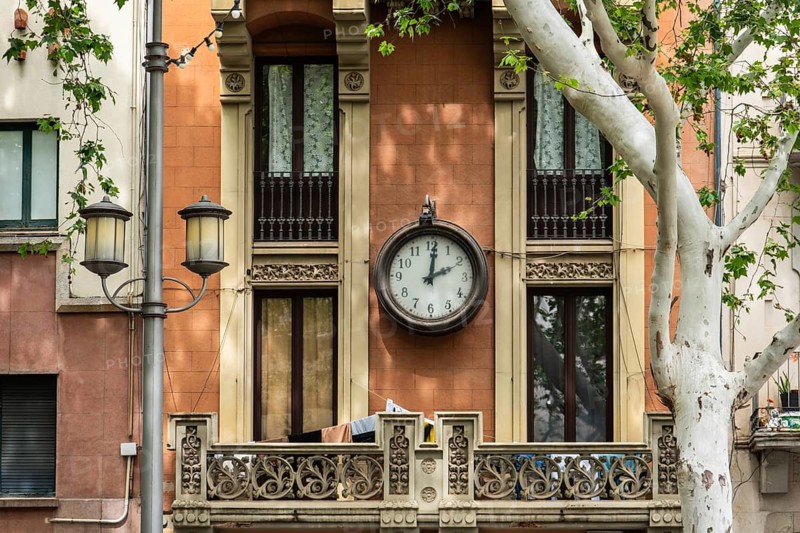 Old clock on a house facade in Figueras, Spain