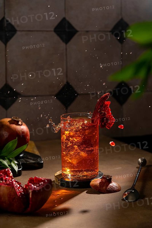 A crisp image of a refreshing pomegranate drink with a splash, symbolizing freshness and vigor, set against a richly textured kitchen background