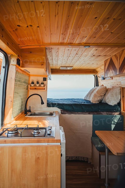 A perfect blend of travel and teleworking in a cozy camper. This mobile home features a compact kitchen, comfortable sleeping area, and an inviting workspace