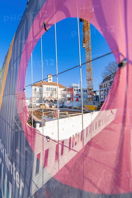 View through a colourful fence onto a construction site and buildings, Sindelfingen, Böblingen district, Germany