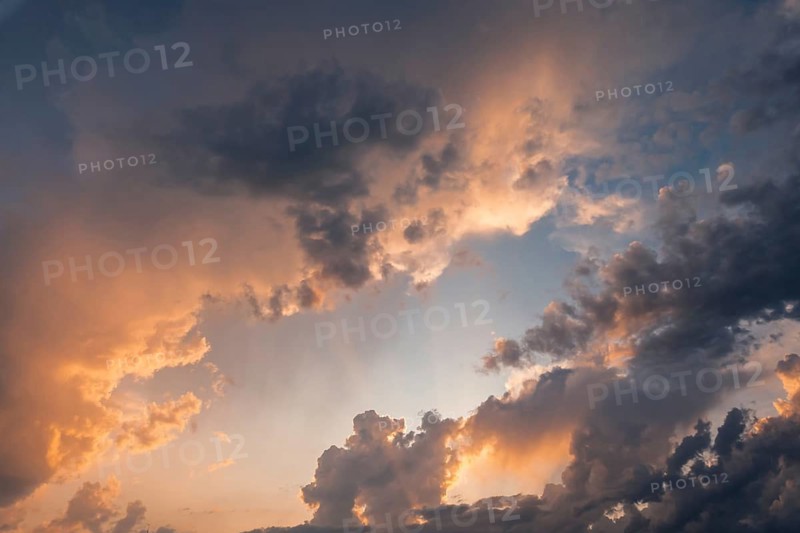 A breathtaking view of a dramatic sunset sky filled with vibrant golden clouds. The warm colors blend seamlessly, creating a serene, mesmerizing atmosphere