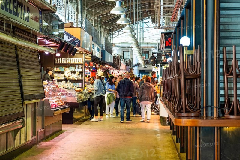 Market stalls with visitors in the Mercat de la Boqueria, famous market on the Ramblas in Barcelona, Spain