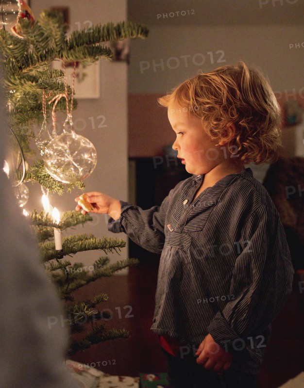 Toddler at the Christmas tree at the family Christmas party, Bonn, 24.12.2023. Toddler at the Christmas tree