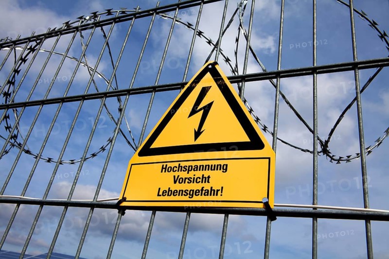 Signpost and fence at an open space solar photovoltaic plant, Germany