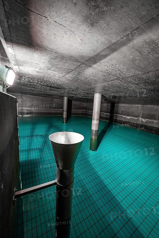 Cavity with blue water and metallic inlet funnel, ENCW Netze Calw waterworks, Calw, Black Forest, Germany