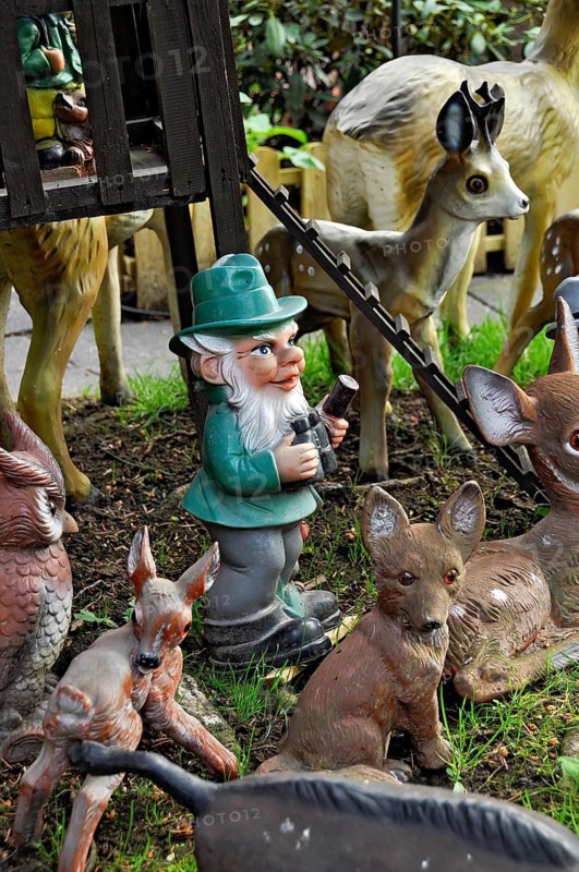 Garden gnomes, foresters with animals in the forest, in a front garden on a flower meadow with daisies in spring, Büdingen, Hesse, Germany