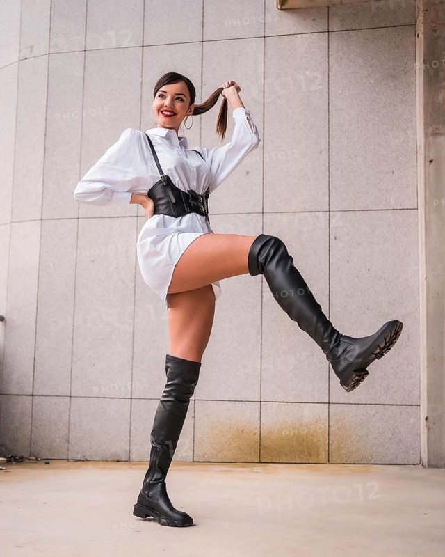Young caucasian girl with white shirt and black leather boots. Enjoying the holidays in the city, smiling and making a long walk and lengthening the foot