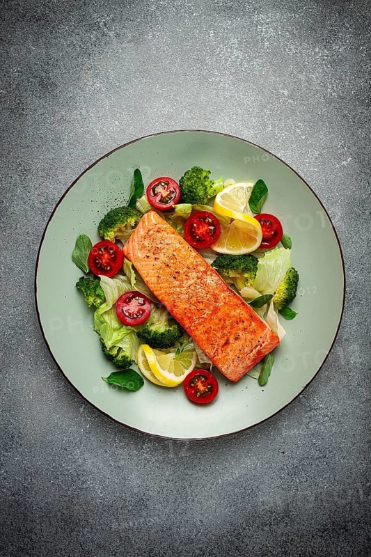 Grilled salmon fillet, with vegetables, broccoli, cherry, iceberg lettuce, spices and herbs, homemade, no people