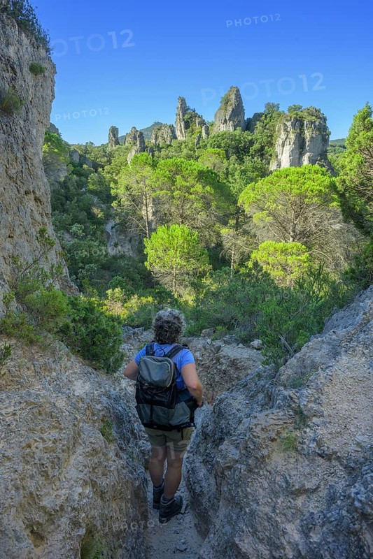 Woman with hiking backpack in the rock labyrinth of Mourèze, Département Hérault, France