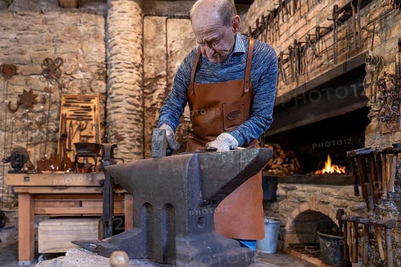 An elderly blacksmith works in his traditional workshop in the Salzburg region of Austria, keeping the centuries-old traditions of blacksmithing alive