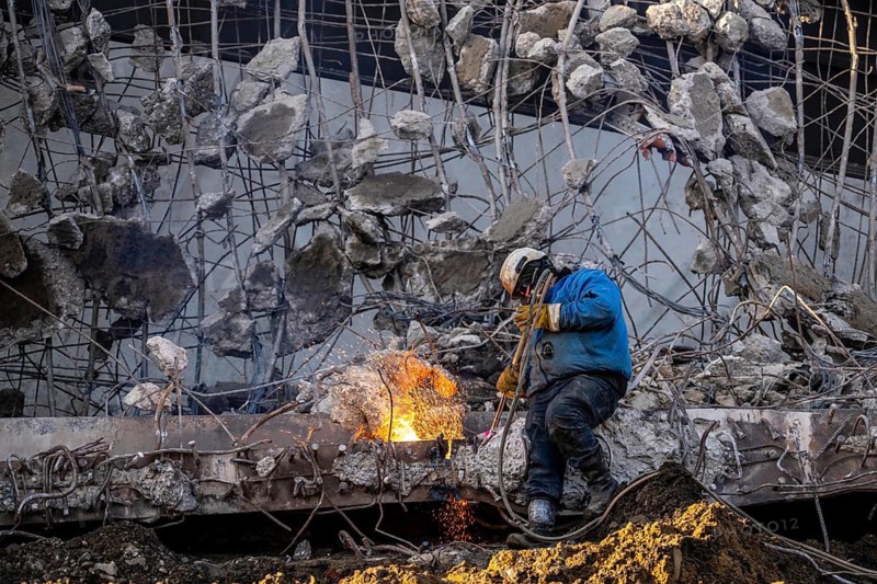 Workers with cutting torches demolishing the 120-meter long motorway bridge of the A516, across Teutoburger Straße in Oberhausen-Sterkrade, the bridge, built in 1970 was severely damaged, traffic continues to roll on the remaining west bridge, after demolition, the eastern part is rebuilt using a process that is unique in the world to date, 40 meter long precast concrete beams are assembled one after the other, reducing construction time from 24 to 7 months, After the completion of this bridge, the western part will also be rebuilt, North Rhine-Westphalia, germany