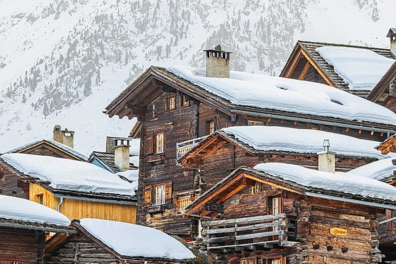 Snow-covered old farmhouses, large wooden cross, historic town center, Grimentz, Val d'Anniviers, Valais Alps, Canton of Valais, Switzerland