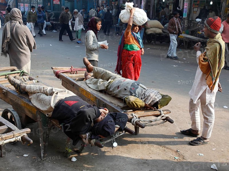 New Delhi, India, 15.01.10 - Market scene, day labourers resting on a sack truck, India