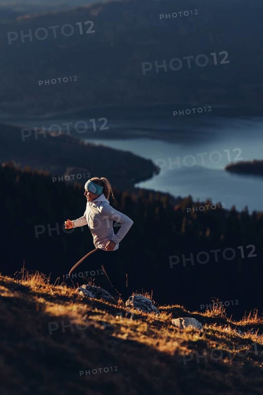 Trail running in autumn on the Jochberg on Lake Walchensee against the wonderful backdrop of the Alps, Bavaria, Germany