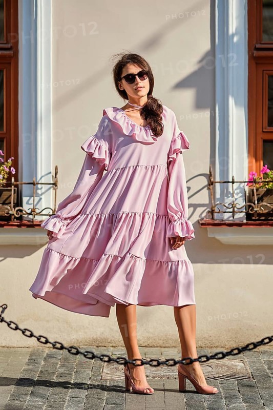 Outdoor urban portrait of young beautiful stylish girl in oversized pink dress