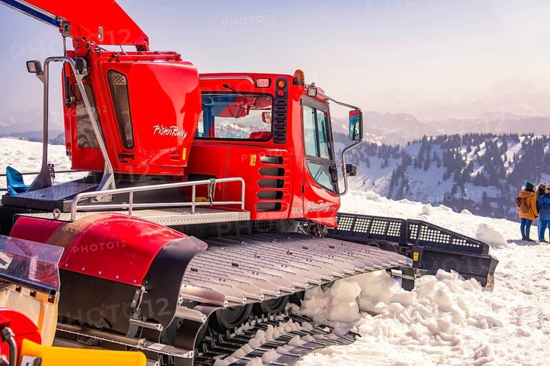 Red snowcat in snowy mountain area with views of the countryside, Hochgrat Mountains, Allgäu Alps, Oberreute, Germany
