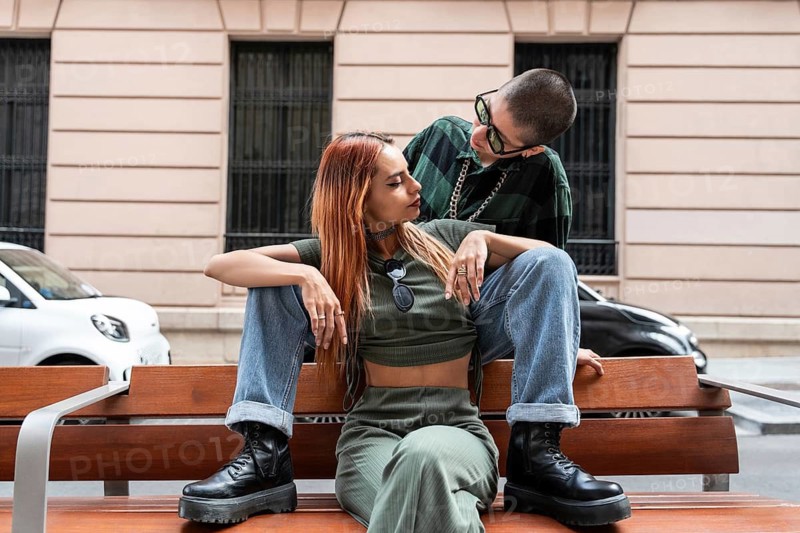 A Colombian lesbian couple sits closely on a bench, conveying love and connection. They embrace diverse identities, celebrating LGBTQIA+ pride and equal rights