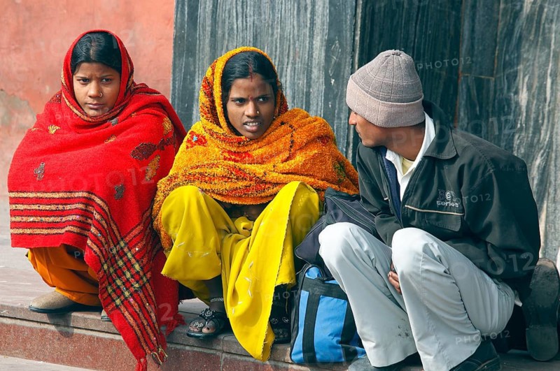 New Delhi, India, 15.01.10 - Two woman in traditional Indian clothes and an Indian man wait at the train station, India