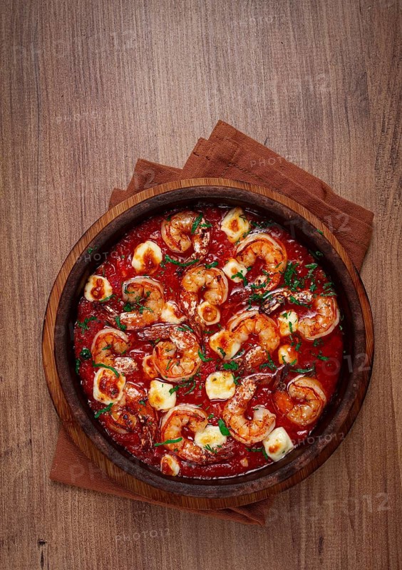 Saganaki with shrimp, in a clay pan, Greek dish, shrimp in tomato sauce, feta cheese, homemade, no people