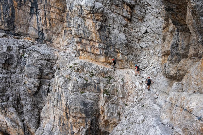 Three hikers on the Via Ferrate Benini via ferrata on a cliff, Brenta Mountains, Parco Naturale Brenta-Adamello, Trentino, Italy