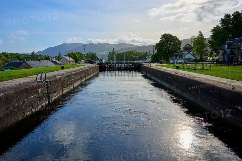 A quiet canal with lock surrounded by green spaces and clear skies, Caledonian Canal, Fort Augustus, Loch Ness, Scotland, United Kingdom, Great Britain