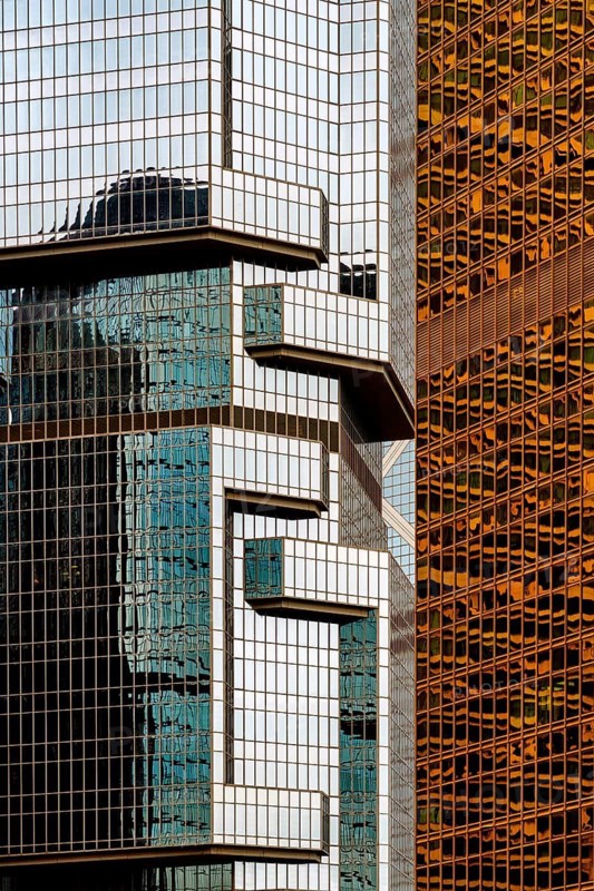 Architectural details showcasing the intricate geometric patterns and reflective surfaces of modern buildings in Hong Kong, emphasizing urban aesthetics and design
