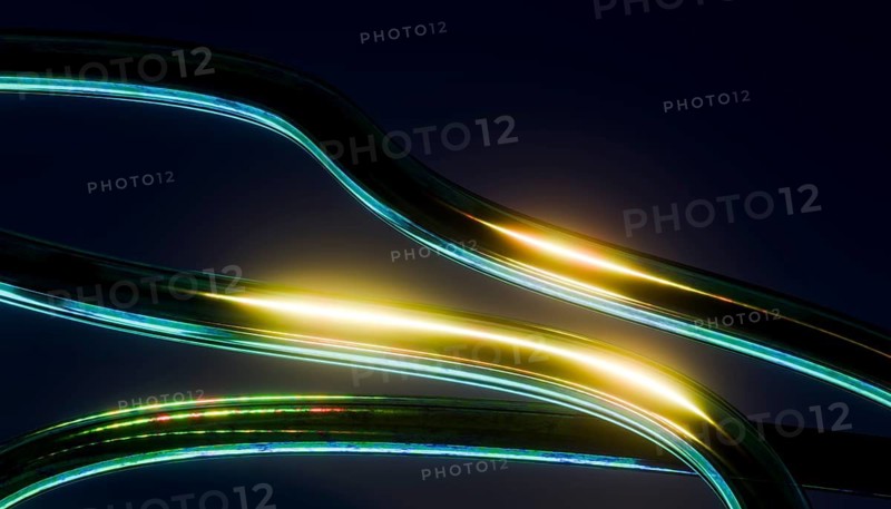 Abstract image 3D of glowing curved lines with vibrant light reflections on a dark background. The smooth, flowing shapes create a dynamic and futuristic visual effect