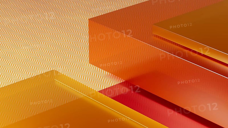 An abstract composition features transparent crystals arranged against a warm-toned background, displaying rich shades of orange and gold