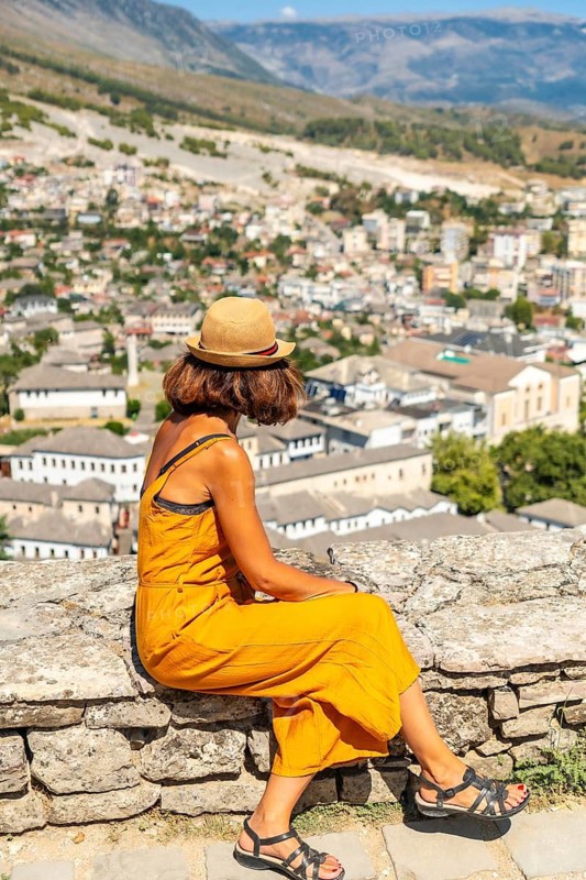 A female tourist looking at the city from the Ottoman castle fortress of Gjirokaster or Gjirokastra. Albanian