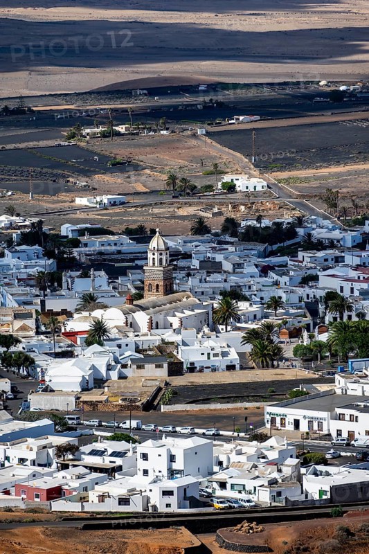 View of town, white houses of Teguise with church tower in dry volcanic landscape, Lanzarote, Canary Islands, Spain