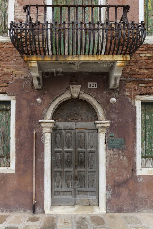 Dilapidated house façade with front door and wrought-iron balcony, Burano, Venice, Veneto, Italy