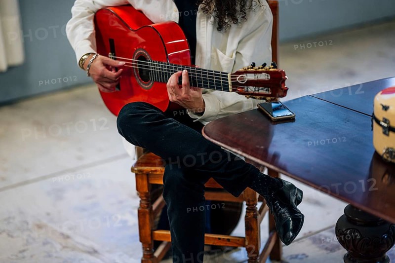 Anonymous Latin man playing red bass guitar in studio