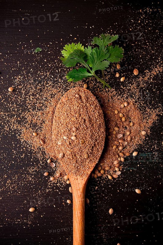 Fresh cilantro, coriander grains and powder, on a wooden table, top view, no people