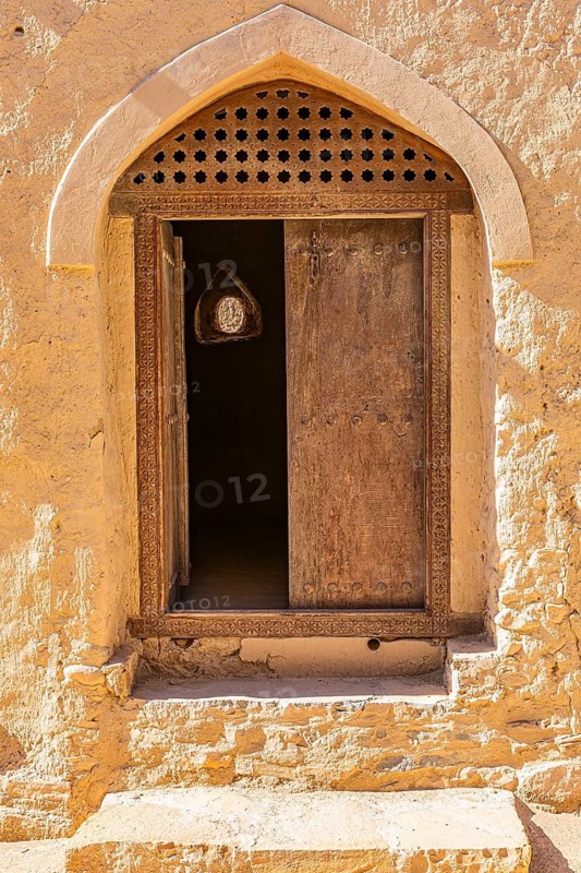 Decorated round arch entrance door in the largest preserved mud town in Oman, Al Bilaad, Al Bilaad Historical Village, Arabian Peninsula, Sultanate of Oman