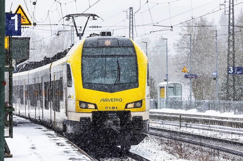 Regional train from Arverio on its way through a winter landscape in snowfall. The railcar train is painted by the Baden-Württemberg mobility brand bwegt. A train on the line in the Deutsche Bahn AG rail network. Amstetten, Baden-Württemberg, Germany