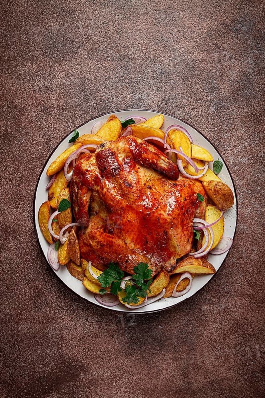 Fried, baked chicken, in the oven, with spices, and rustic potatoes, top view, homemade