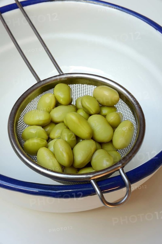 Edamame, unripe cooked soya beans in sieve, Glycine max