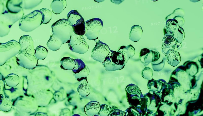 This image features a cluster of 3D liquid spheres intertwined, rendered in an abstract style with a dual-tone color scheme of green and purple, creating a visually captivating texture