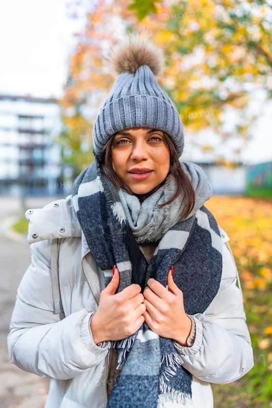 Vertical portrait of a beauty woman with warm clothes in a park in autumn
