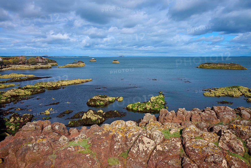 A rugged rocky coastline overlooking the sea under a cloudy sky, Dunbar, East Lothian, Scotland, United Kingdom, United Kingdom