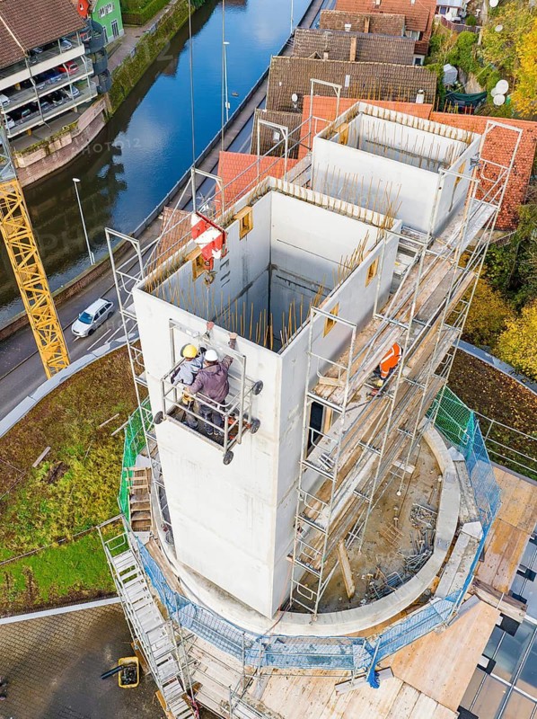 Building construction project near a river, construction workers and crane visible, extension of the Calw railway station for the new track of the Hermann Hessebahn, Calw, Black Forest, Germany