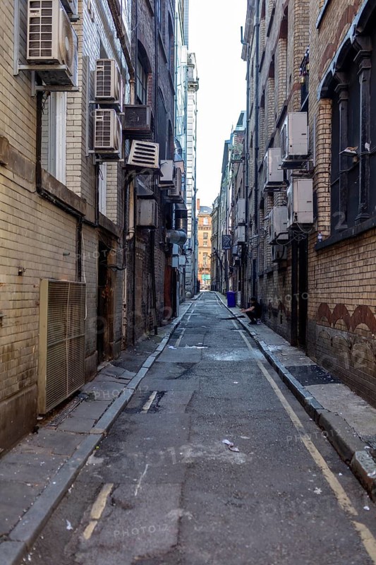 Narrow, functional alleyway between air-conditioned brick walls, Liverpool