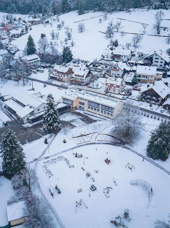 Snow-covered playground and school building in a small village, Enzklösterle, district of Calw, Black Forest, Germany