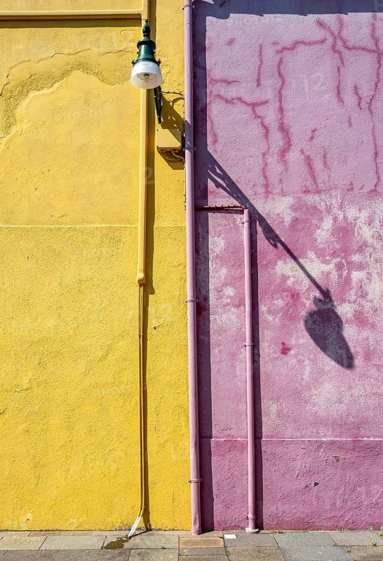 Purple and yellow house facade with street lamp, colourful houses on the island of Burano, Venice, Veneto, Italy