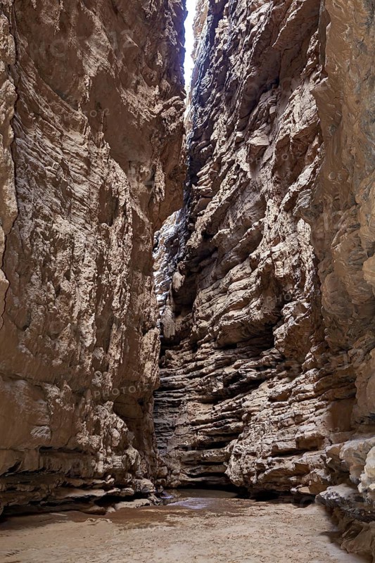A narrow, rocky gorge with high, steep cliffs, rocky landscapes and gorges in the landscape of the Sahara in Algeria